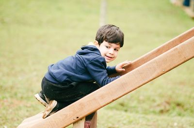 Cute boy playing on slide at playground