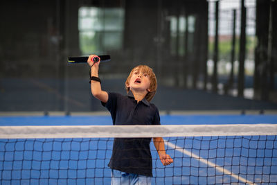 Boy looking away while standing against blurred background