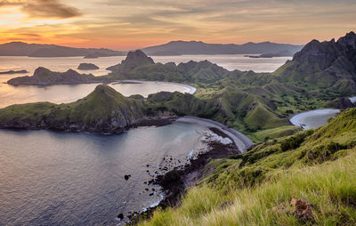 Scenic view of sea and mountains against sky during sunset