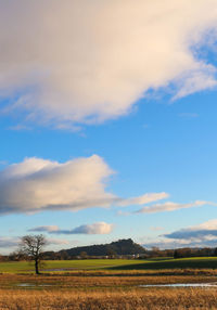 Scenic view of field against cloudy sky