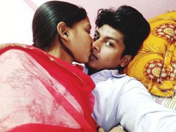 Portrait of young couple kissing on bed