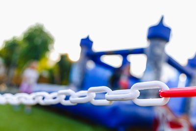 Close-up of metal fence against blue sky