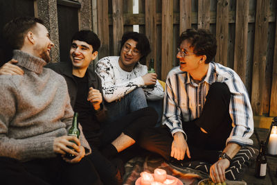 Happy male friends talking with each other in balcony