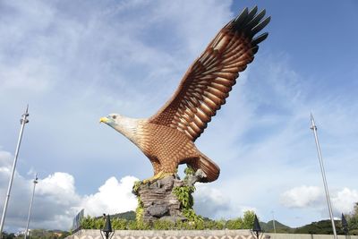 Low angle view of eagle flying against sky