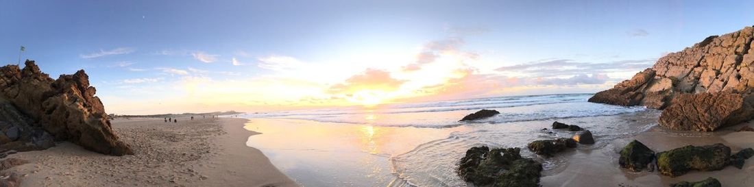 Panoramic view of beach against sky during sunset