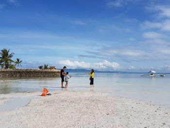 People on beach against sky