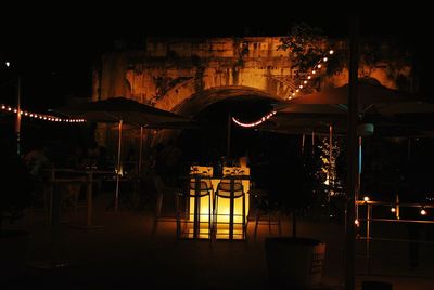 Illuminated restaurant by buildings in city at night