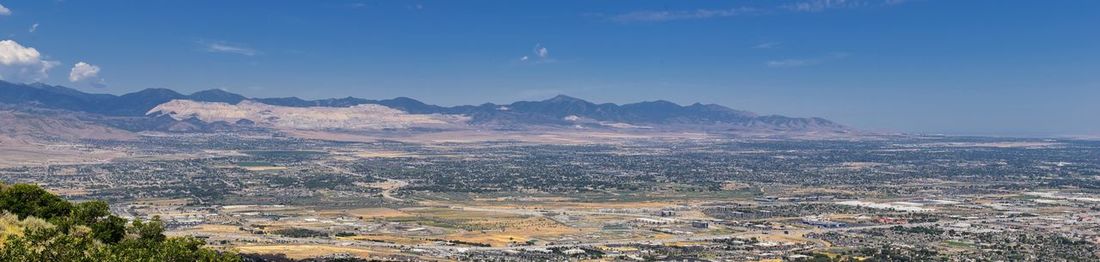 Aerial view of landscape and mountains against blue sky