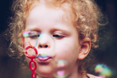 Close-up of cute girl blowing bubbles
