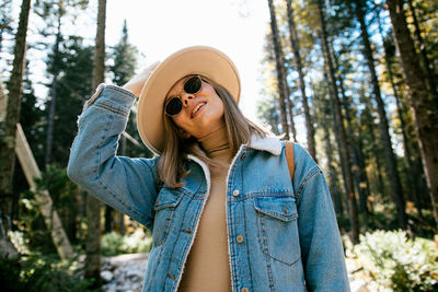 Young woman wearing hat standing in forest