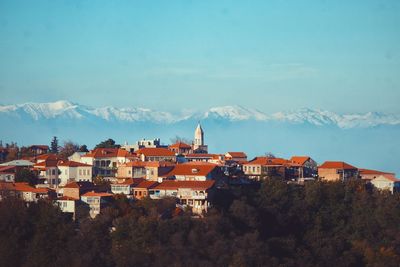 Residential buildings in town against blue sky