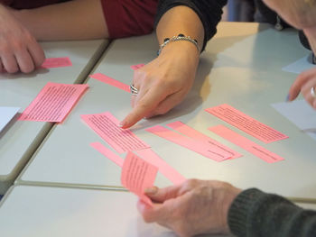 Midsection of business colleagues discussing over papers on table