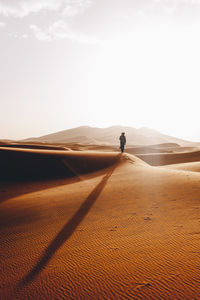 Man on desert against sky