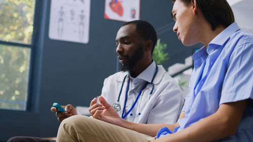 Side view of doctor examining patient at clinic