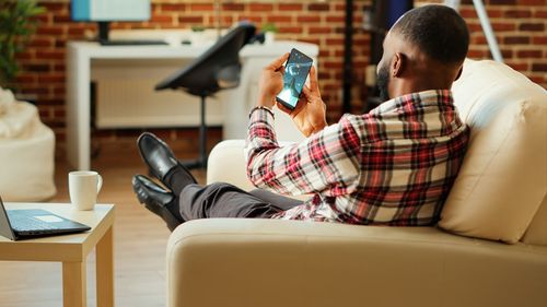 Young woman using mobile phone while sitting at home