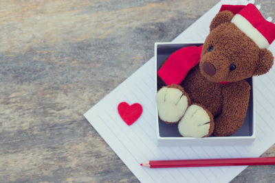 High angle view of teddy bear in box on wooden table