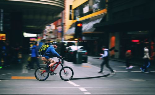 Man riding bicycle on road in city