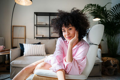 Young woman sitting on sofa at home