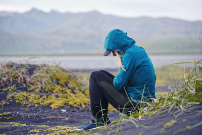 Side view of woman sitting on field