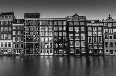 Exterior of buildings by canal against sky in city