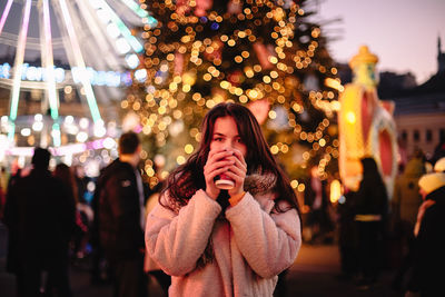 Portrait of teenage girl drinking mulled wine in christmas market