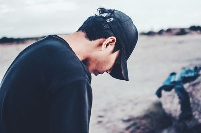 Side view portrait of young man standing on beach