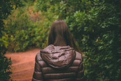 Rear view of woman standing amidst trees