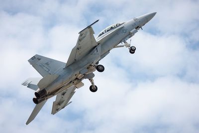 Low angle view of military airplane flying in sky