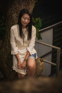 Portrait of young woman sitting on rock