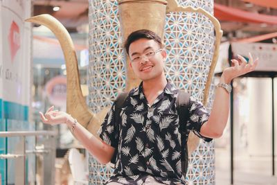 Smiling young man standing in column