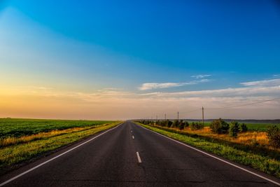 Road passing through land against sky