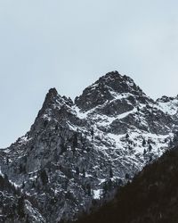 Low angle view of snowcapped mountains against clear sky