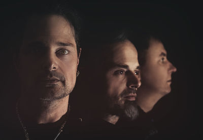 Close-up portrait of young man against black background