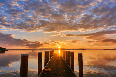 Pier over sea against sky during sunset