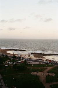 High angle view of city by sea against sky