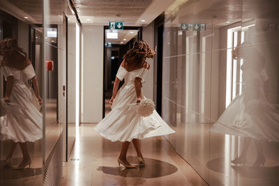 Rear view of woman standing in corridor