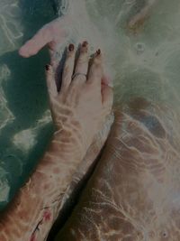 Close-up of hand with fish in water