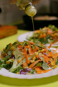 Dressing mixed salad with virgin olive oil, vegan dish