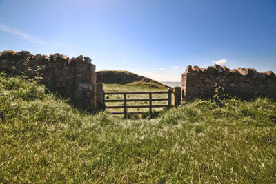 View of old ruin on field against sky