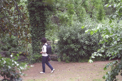 Woman wearing backpack while walking at park