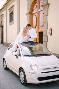 Couple embracing while standing in car