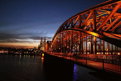 View of bridge over river at night
