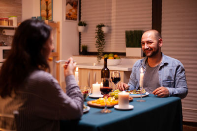 Smiling friends having food at home