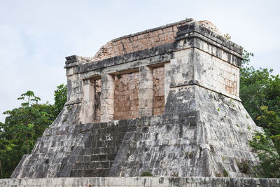 Low angle view of old ruin building against cloudy sky