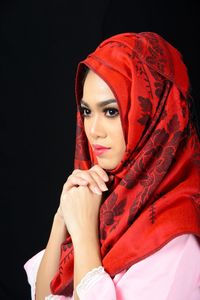 Portrait of a beautiful young woman against black background