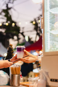 Woman hand passing a drink to customer in a shop.