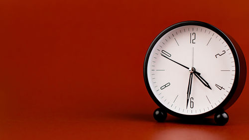 Close-up of clock on yellow background