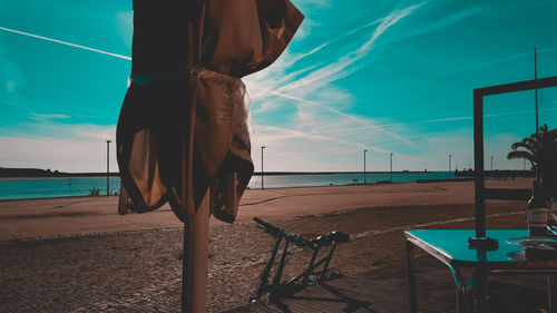 Low section of man on beach against blue sky