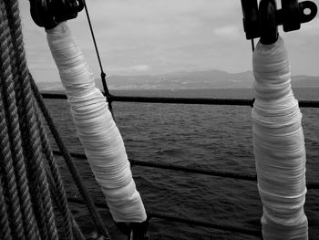 Clothes hanging on rope against sea against sky