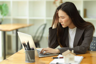 Frustrated businesswoman using laptop at office